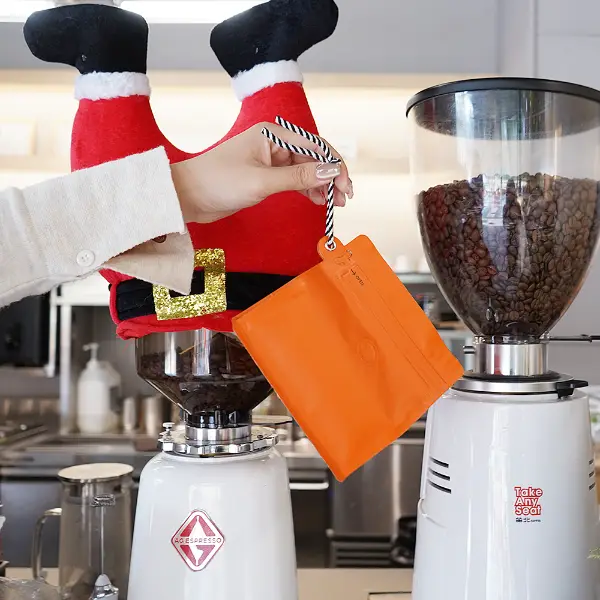 Tenere in mano sacchetti da caffè da 150g con cordino in caffetteria