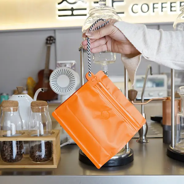 Tenere in mano sacchetti da caffè da 250g con cordino in caffetteria