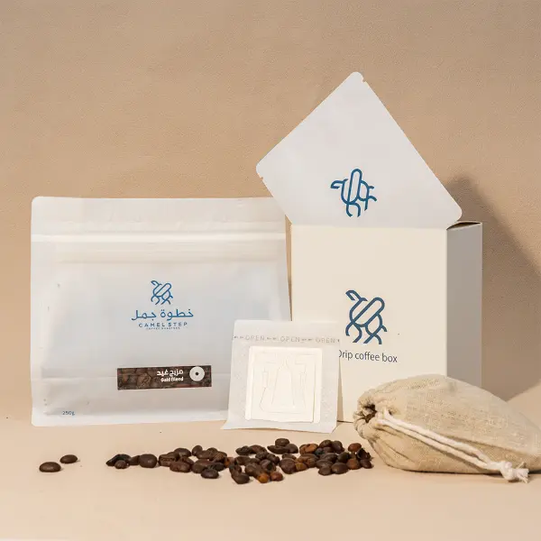 Scatola di carta stampata su misura con sacchetti di caffè, confezione di caffè a goccia, e fagioli in uno studio pulito