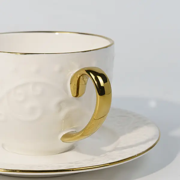 Dettaglio dell'impugnatura dorata della tazza in ceramica in rilievo personalizzata