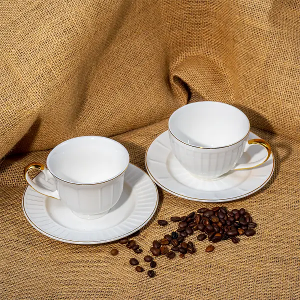 Tazza in ceramica in rilievo dipinta d'oro personalizzata con piattino esposto con chicchi di caffè