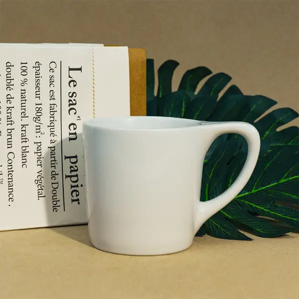 Tazza da caffè in ceramica a bocca piatta con bordo liscio e design minimalista bianco