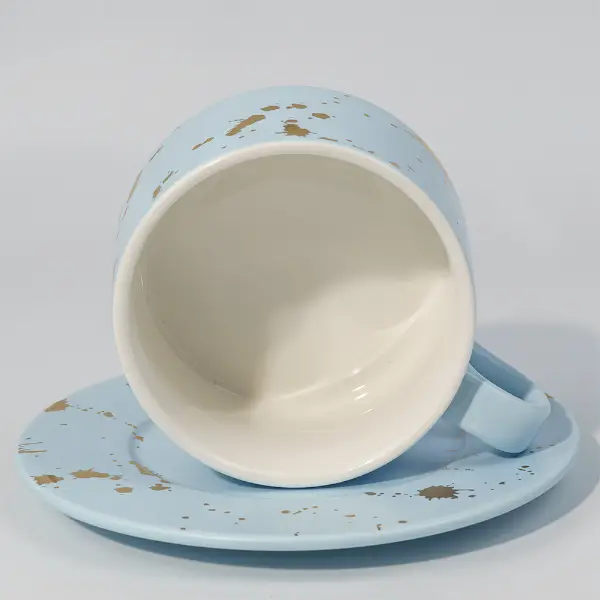 Tazza e piattino in ceramica dorata per il servizio caffè e tè