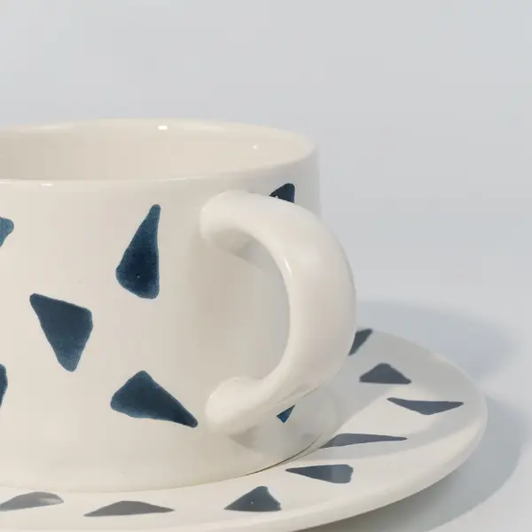 Primo piano del manico su una tazza da caffè in ceramica stampata con stampa decorativa